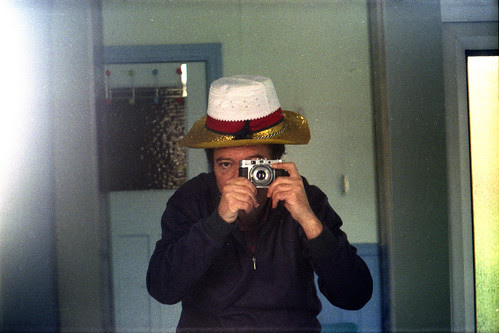 reflected self-portrait with Agilux Agimatic camera and three hats by pho-Tony