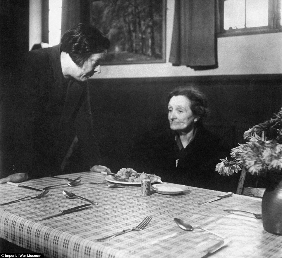 Digging in: A woman made homeless by the Blitz receives a hit meal at a welfare centre in Bermondsey, London, in 1940