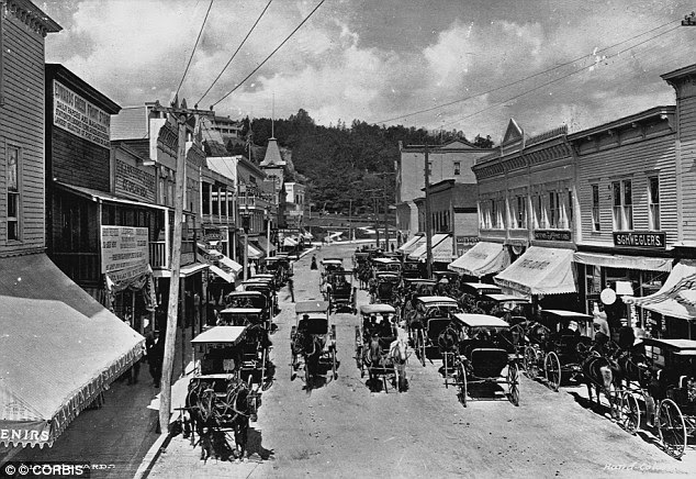 Pictures of the past: In the late 19th century, horse-drawn carriages file past Main Street storefronts on Mackinac Island in Michigan