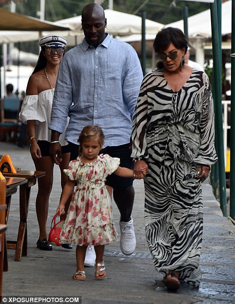 Doting grandma: Kris wore a stylish zebra-print maxi dress as they strolled along the water