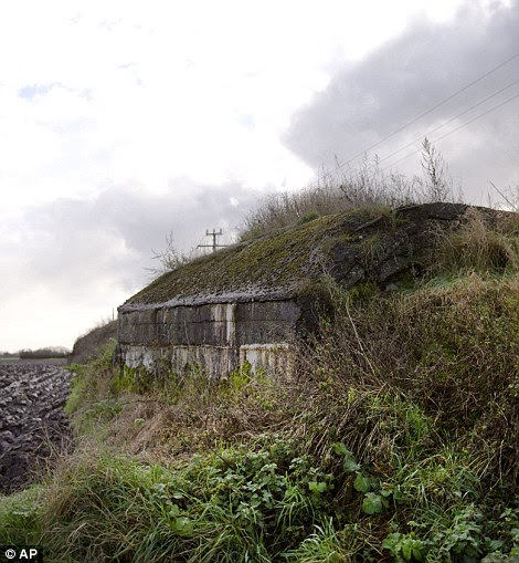 A bunker next to a muddy field in La Bassee, France (left, Dec 6)