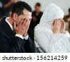 Muslim bride and groom at the mosque during a wedding ceremony - stock photo