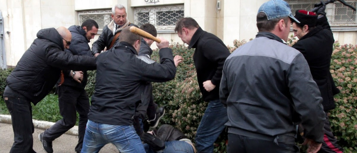 Pro-Russian "self-defence" activists use a bat and a whip to beat a pro-Ukrainian supporter during clashes in Sevastopol on March 9, 2014. Pro-Kiev and pro-Moscow groups clashed in the Crimean city of Sevastopol on March 9 following a rally in support of Ukraine