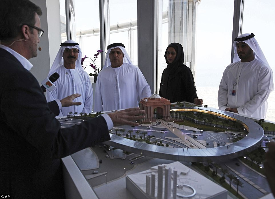 Rob Lloyd, the CEO of Hyperloop One, left, shows a model to Emirati officials including Mattar al-Tayer, the director-general and chairman of Dubai's Roads & Transport Authority, third left, in Dubai.