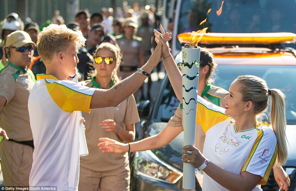 Coca-Cola da tocha olímpica ao Portador (e irmão mais velho) Cody Simpson mãos a tocha para sua irmã mais nova Alli antes de sua tocha olímpica passar por Rio de Janeiro