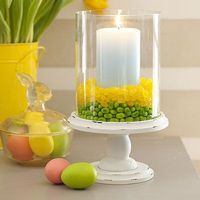 Place a glass hurricane on a plate or pedestal. Center a pillar candle inside it. Fill the surrounding space 1" high with one color of jellybeans, then add a 1" layer of a different color directly on top.