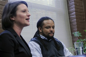 20131119lrhendersonlocal06-5 Dennis Henderson listens to ACLU attorney Sara Rose, left, Tuesday as she announces the filing of a lawsuit against Pittsburgh police Officer Jonathan Gromek, accused of violating Mr. Henderson's civil rights during an arrest in Homewood in June.