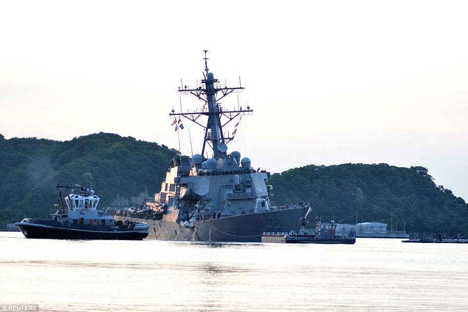 Limping home: The USS Fitzgerald makes its way back to Yokosuka Naval Base, just south of Tokyo on Saturday with the help of tug boats