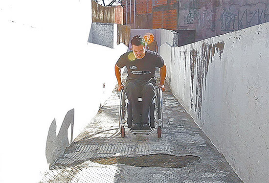 Aluno cadeirante passa por caminho esburacado em escola da zona norte de São Paulo