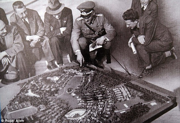 Adolf Hitler (center) admires a model of the village which was purpose built for the games. He promised German supremacy and intended them to prove his bizarre theories on race