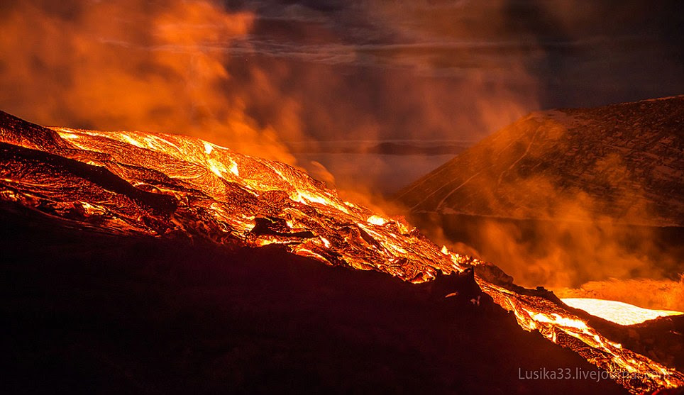 Up close: The lava river sizzles and heats up the cold air over the volcano as the photographers overcome their fears and stand on its brink