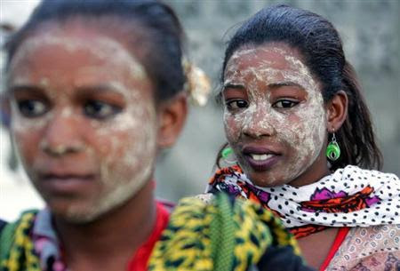 Comoran women with faces smeared yellow by the herbal lotion popular in the islands attend a welcoming ceremony for Said Larifou in Foumboni village, Comoros Islands April 21, 2005. REUTERS/Radu Sigheti/Files