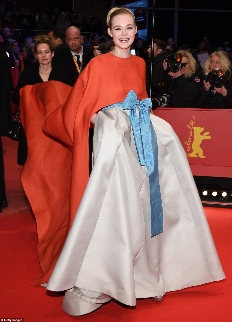 Upbeat: The young actress was in high spirits as she received some assistance with her sweeping dress