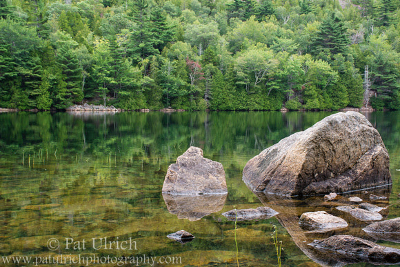 Photograph of boulders and forests reflected in Bubble Pond, Acadia National Park