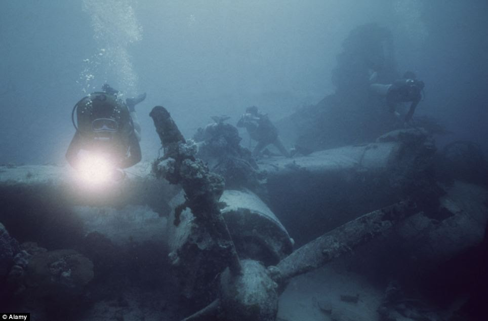 Depths: Several divers explore the wreckage of a sunken aircraft in the lagoon 