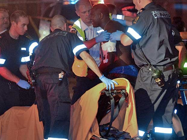 Um ferido recebe atendimento no local onde tiroteio mataram ao menos duas pessoas em Toronto, no Canadá. (Foto: Rick Madonik / The Canadian Press / Toronto Star / AP Photo)