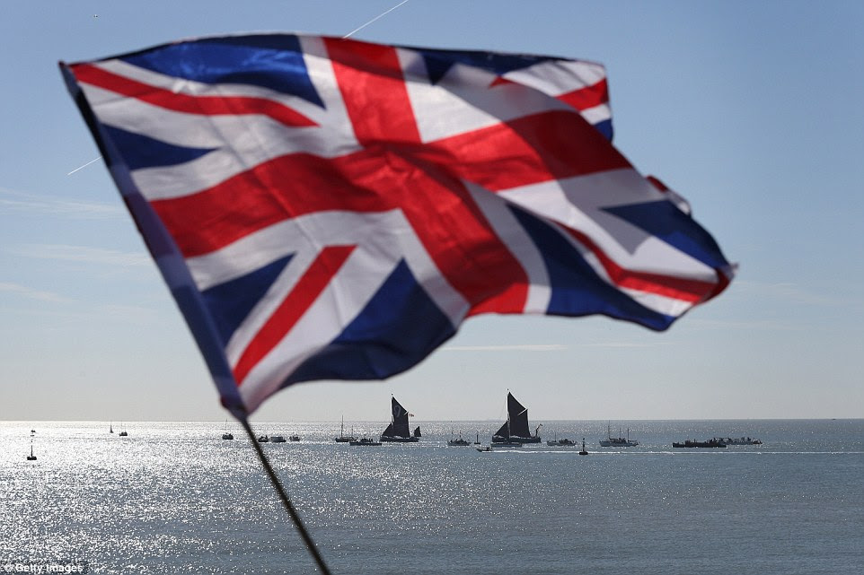 Breathtaking: A Union flag blows in the wind as little ships are seen heading out into open water from the English coast