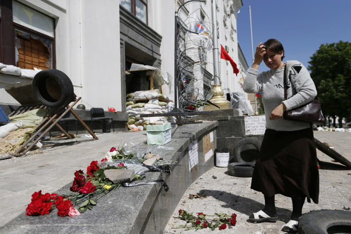 A woman places flowers near the site of an explosion in a regional administration building in the eastern Ukrainian city of Luhansk June 3, 2014. (Reuters/Gleb Garanich)