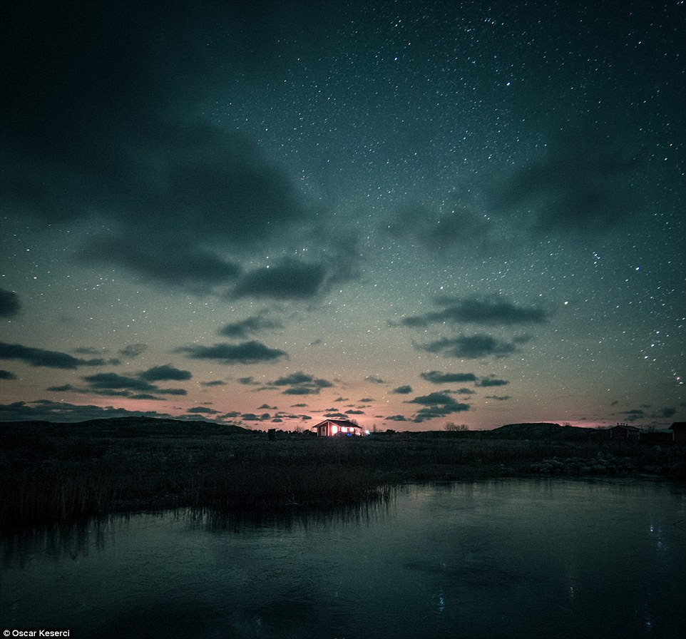 Endles céus: Uma única casa iluminada sob um céu estrelado parece atraente neste tiro ao lago em Jurmo, Finlândia