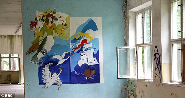 Eerie reminder: Brightly coloured murals featuring swans and ships remain on the walls of the camp's school