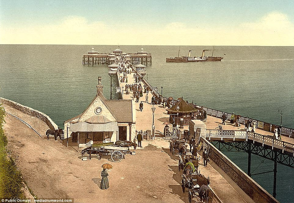 I do like to be beside the seaside: A seaside pier appears to be a popular spot with day trippers with the promenade teeming with people 