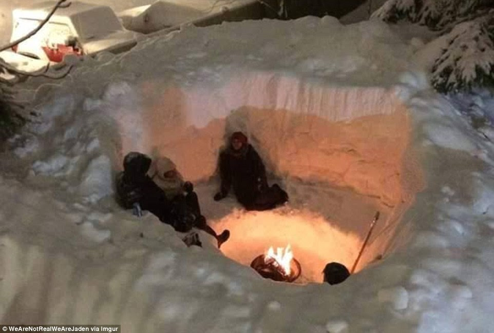 Keeping warm: This photo, posted online, shows Boston residents sitting beside in a fire in a hole they carved out of a huge snow pile