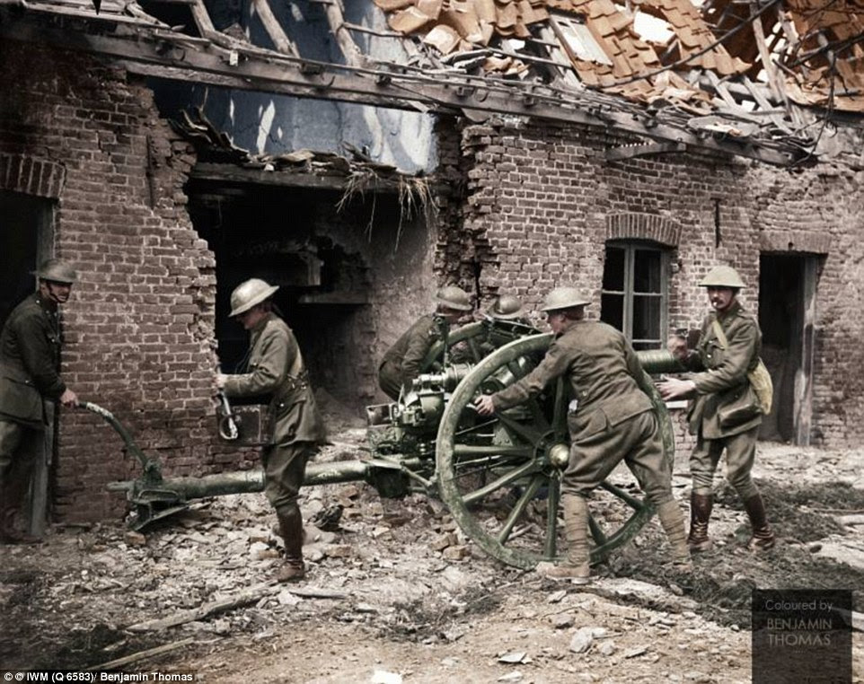 Gunners in the Royal Field Artillery moving an 18 pound gun into firing position next to a ruined home during the Battle of Lys in May 1918 (pictured)