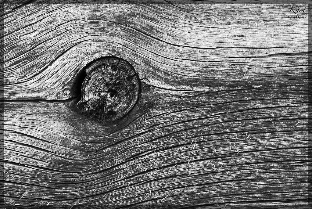A very old wooden board with a knot in it.