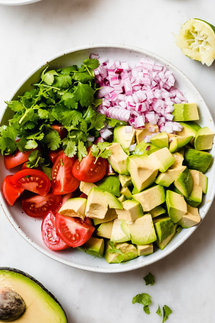 Easy Guacamole Salad - turn everyone's favorite dip into a salad! This avocado salad is sure to be a hit with everyone at potlucks, barbecues, or parties this summer! #summersalad #guacamole #guacamolesalad #deconstructedguacamolesalad #avocadosalad #tomatoavocadosalad | Littlespicejar.com
