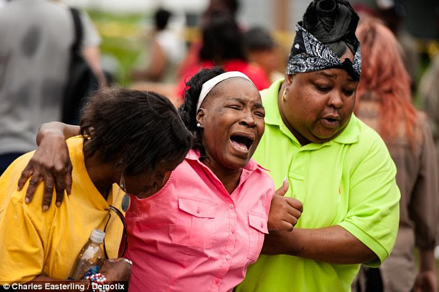 Grief: A grief stricken woman cries after a relative is shot. The shooting was described by the FBI as a flare-up of street violence