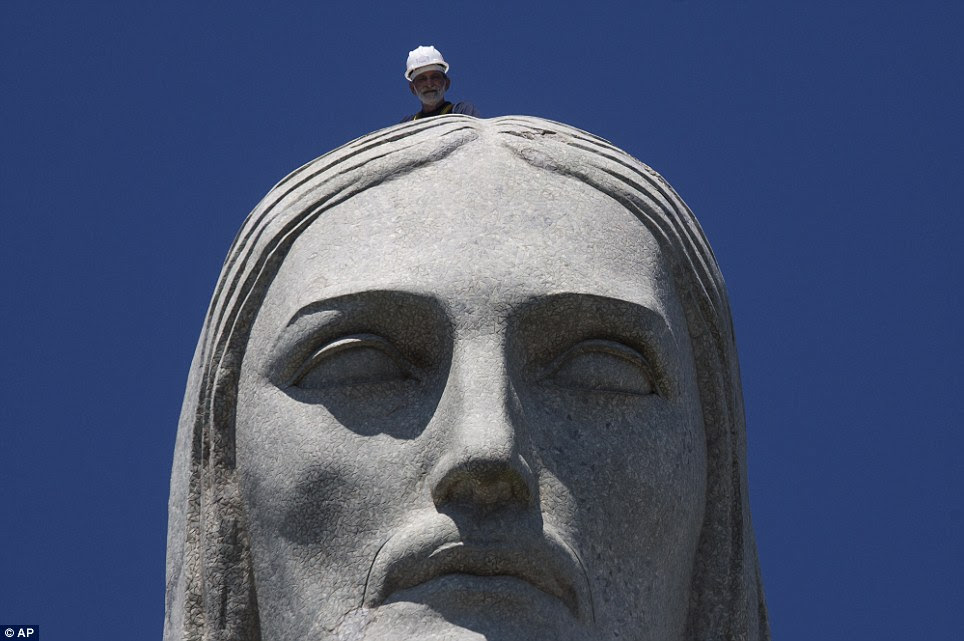 Peek-a-boo: A repair worker examines the head of Christ Redeemer statue in Rio de Janeiro