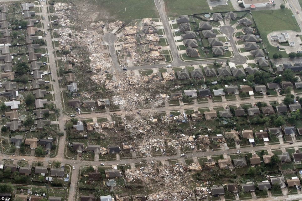 Path of destruction: This aerial photo shows the remains of homes hit by a massive tornado - while other houses either side are barely touched