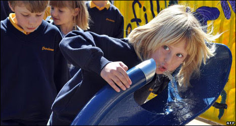 Girl drinks water from fountain