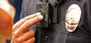 LOS ANGELES, CA - SEPTEMBER 04: Los Angeles Police Officer Jim Stover, with Information Technology Bureau demonstrates how an officer turns on the new LAPD body camera during a press conference at LAPD Mission Division Friday September 4, 2015 as they talked about the rollout of the agency's officer body cameras. The rollout of the body cameras began last Monday at LAPD's Mission Division in the north San Fernando Valley when officers received final instructions on using the cameras during roll call training sessions. About 1,000 video were recorded during the first two days of operation, according to Mayor Eric Garcetti. (Photo by Al Seib/Los Angeles Times via Getty Images)
