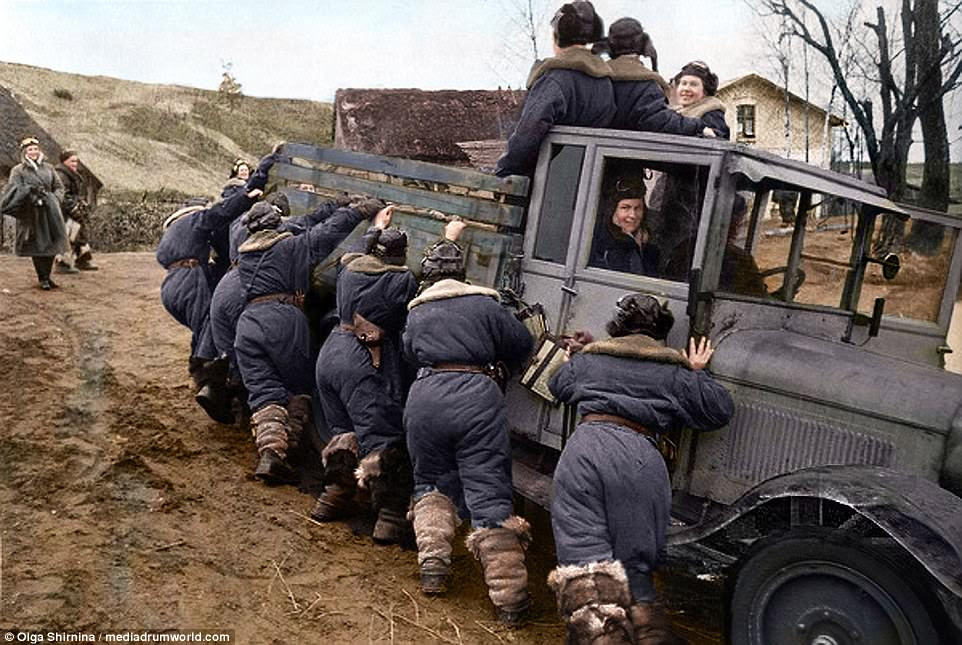 Team effort: Colourised photographs show the feared Night Watch division in Crimea in 1944as they push a truck up a hill