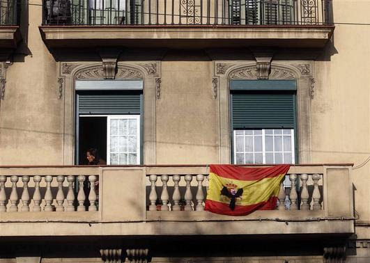 A black ribbon is seen on a Spanish flag at a balcony in Barcelona December 13, 2013. REUTERS-Albert Gea