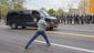  A youth throws an object at a passing police vehicle