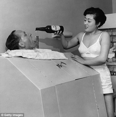 A Japanese hostess, not an official geisha, pours beer into a man's mouth while he relaxes in a steam bath in 50s Japan