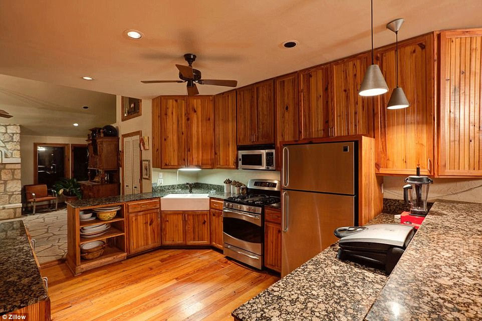 The kitchen has been updated with granite countertops, gas range stove, and stainless appliances