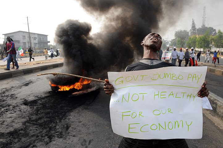 Nigeria fuel protests: A man carries a placard during a demonstration 