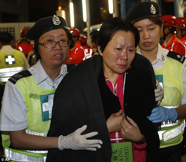 Trauma: A visibly distressed survivor is helped to safety by two rescuers following the disaster