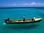A fishing boat motors on clear waters off Jamaica.