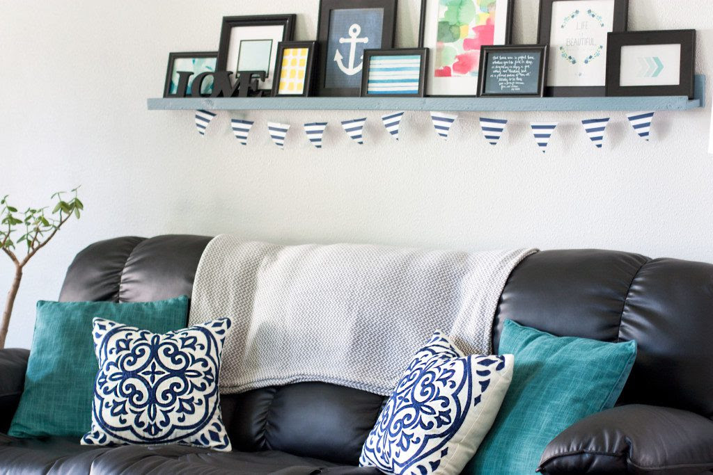 This living room looks so pretty! Love all of those blue pillows and that picture ledge/gallery wall.
