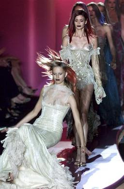 A model slips on her gown and falls to the catwalk at the end of Italian designer Donatella Versace's Autumn-Winter 2002-2003 Haute Couture collection in Paris, July 8, 2002. REUTERS-John Schults