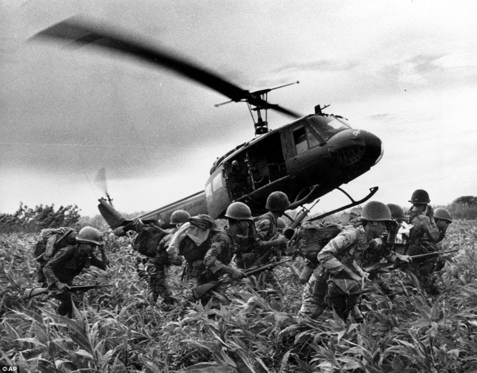 Vietnamese Marines rush to the point where a descending U.S. Army helicopter will pick them up after a sweep east of the Cambodian town of Prey-Veng in June 1970