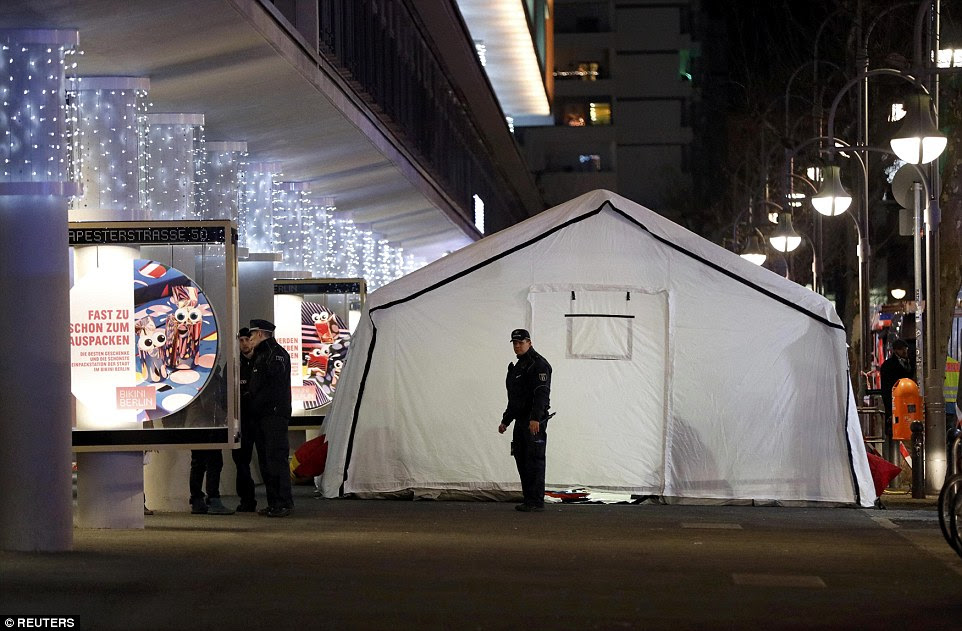 A polícia do lado de fora de uma tenda perto do mercado de Natal em Berlim como os feridos no acidente devastador são tratados