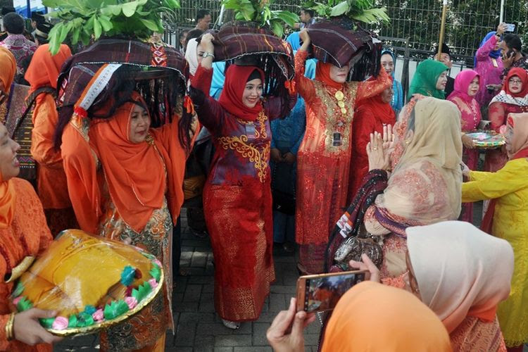 Sejumlah kerabat dan keluarga marga Siregar membawa persembahan Itak Godang ketika mengikuti ngunduh mantu pernikahan Kahiyang Ayu-Bobby Nasution, di Medan, Sumatra Utara, Jumat (24/ 11). Itak Godang adalah barang bawaan berbungkus kain ulos warna hitam dan merah yang dibawa oleh para ibu pihak keluarga Siregar. Bungkusan ini berisi aneka makanan khas suku Mandailing untuk persembahan khusus dari pihak keluarga marga Siregar kepada pihak pengantin.
