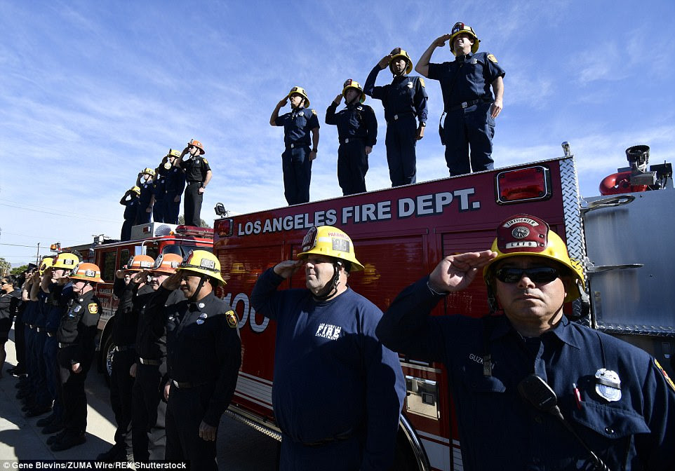 Los Angeles city firefighters stand to attention and salute the Cal-Fire funeral procession of fallen Cal Fire San Diego engineer Cory Iverson Sunday