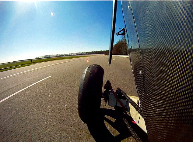 On the ground, the machine handles midway between a racing bike and a car, leaning into turns