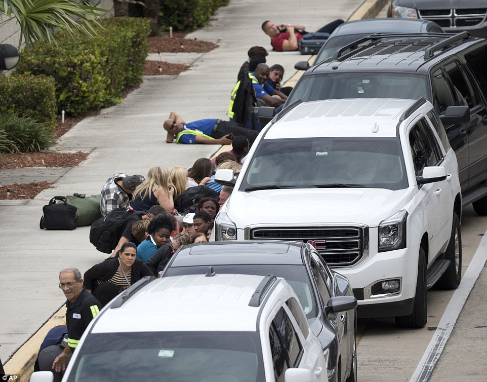 People take cover outside Fort Lauderdale-Hollywood International Airport, Friday, Jan. 6